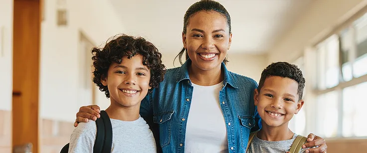 Professorea feliz abraçando alunos com o uso da IA na Educação